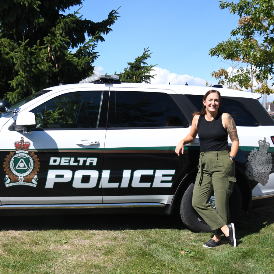 Image of Sgt. Garcia posing in front of Delta Police car